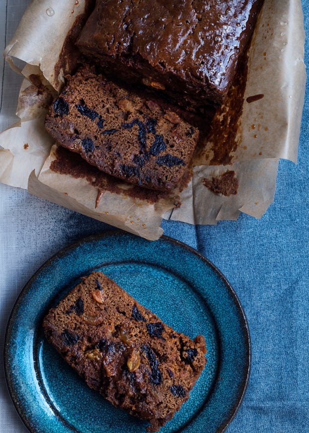 malt loaf in parchment paper and a slice of it on a round plate